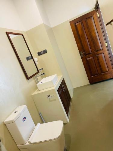 a bathroom with a toilet and a sink at The Arch View in Habaraduwa