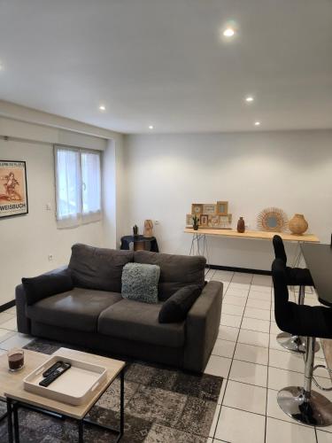a living room with a couch and a table at Les Pierres de Rinaldi in La Celle-sous-Gouzon
