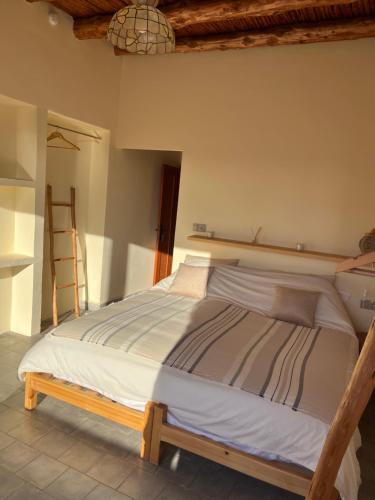 a bedroom with a bed with a wooden frame at Villa'S in Zaouiet Bouzarktoune
