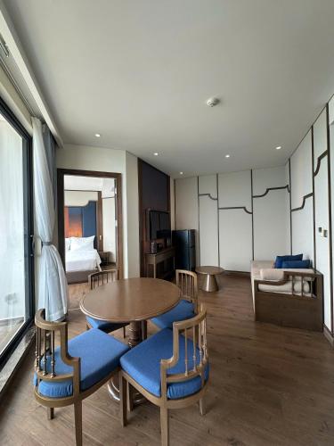 a room with a table and chairs and a bed at Apec Mandala wyndham Apartment - APEC Mui Ne in Mui Ne