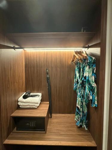 a walk in closet with a baseball bat and a shirt at Apec Mandala wyndham Apartment - APEC Mui Ne in Mui Ne