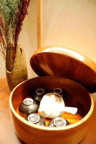 a wooden bowl filled with black stones and a vase at Fujiyoshida house, 2 toilet 2 bathroom, Mt Fuji view, 4 living room, free parking 5 cars, projector, washmachine, pet ok in Minamitsuru