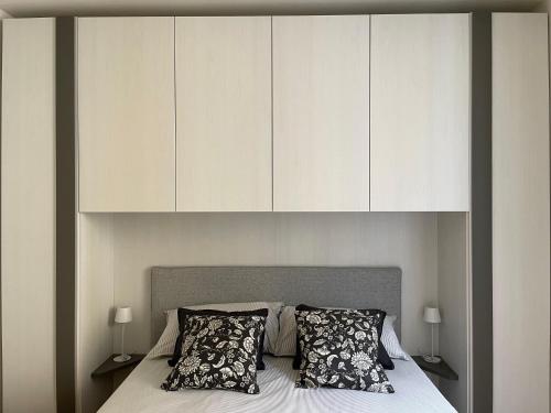 a bedroom with a bed with white cabinets above it at Torretta House in Locarno