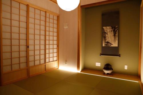 a room with a door and a cat sitting on the floor at Fujiyoshida house, 2 toilet 2 bathroom, Mt Fuji view, 4 living room, free parking 5 cars, projector, washmachine, pet ok in Minamitsuru
