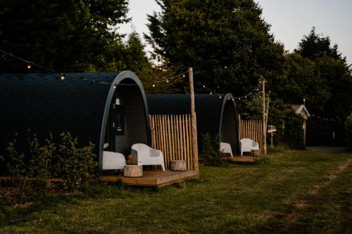a group of chairs in a yard with a tent at Knus Natuurhuisje met Hottub - Ontspannen in de natuur in Jubbega-Schurega