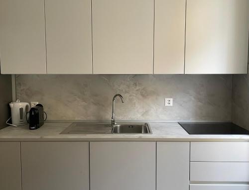 a kitchen with white cabinets and a sink at Torretta House in Locarno
