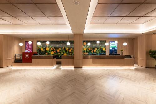 a lobby with a waiting area with flowers on the wall at Orange Sanhe Century Plaza Hotel in Sanhe
