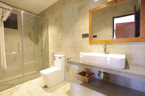 a bathroom with a toilet and a sink and a shower at Chaza Oddington in Lindula