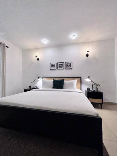 a bedroom with a large white bed and two lamps at Camellia Residencies Colombo Sri Lanka in Colombo