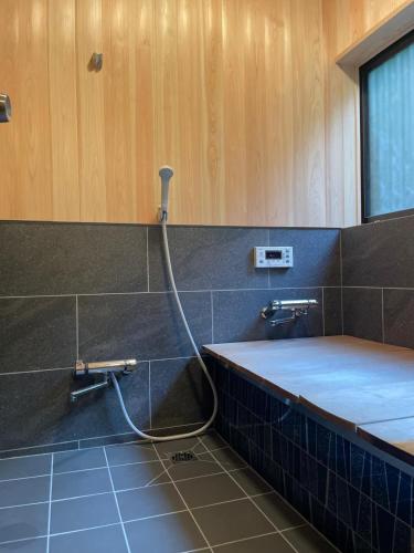 a bathroom with a hose hooked up to a sink at Kanoto DE Sauna in Motojuku