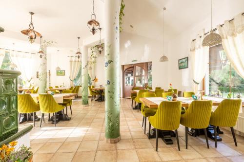 a dining room with tables and yellow chairs at Pensiunea Sibiel in Sibiel
