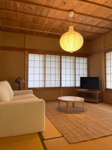 a living room with a couch and a coffee table at Kanoto DE Sauna in Motojuku