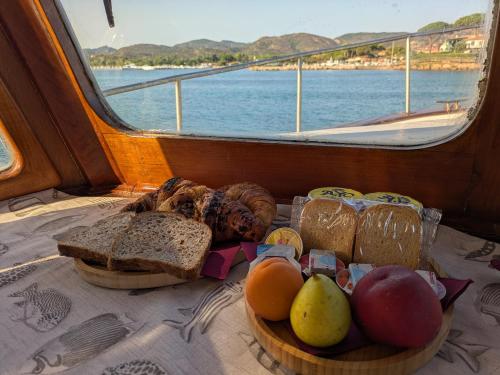 a plate of bread and fruit on a boat at Che Manovra - A Night Onboard! in Porto San Paolo