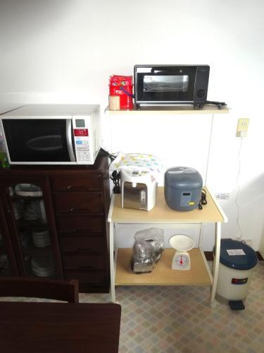 a microwave and a toaster oven on a table at Guest House 紫-YUKARI- in Kami-furano