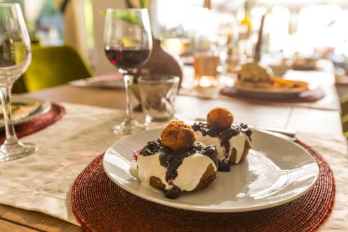 a plate of food on a table with wine glasses at Pensiunea Sibiel in Sibiel