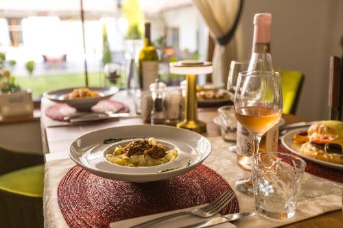 a table with a plate of food and a glass of wine at Pensiunea Sibiel in Sibiel