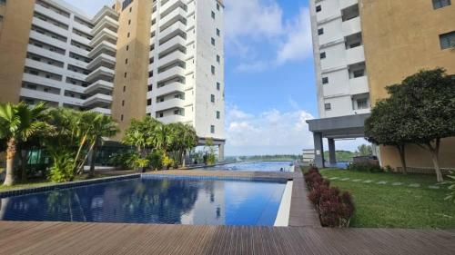 a swimming pool in the middle of two tall buildings at PD D'Wharf The Bay Superior Queen Room SeaView Balcony in Port Dickson