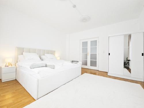 a white bedroom with a white bed and a white rug at Cozy Apartment Szentendre in Szentendre