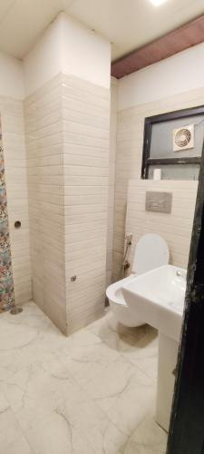 a bathroom with a toilet and a sink at Airport Hotel The Paramont Palace Inn New Delhi in Jāmb