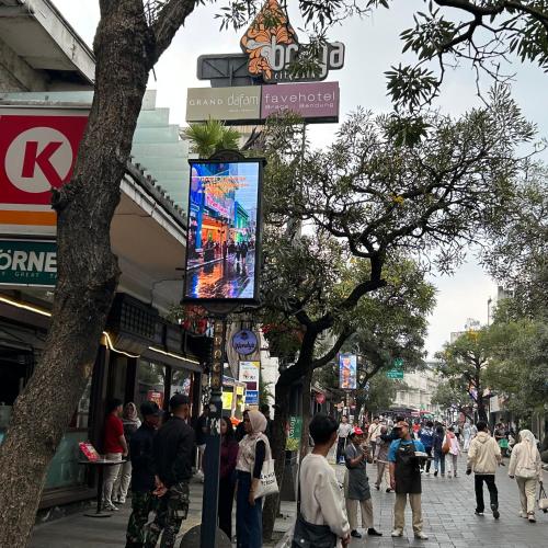 a crowd of people walking down a busy city street at Apartment 3 BR Luxurious Braga Citywalk in Bandung