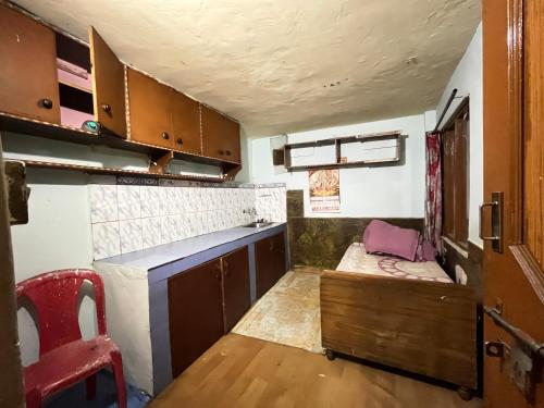 a small kitchen with a table and a red chair at Star Manali in Palchān