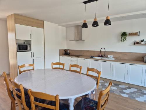 une cuisine avec une table et des chaises dans une pièce dans l'établissement Maison familiale entre mer et foret 6 pers - Clim, à Saint-Trojan-les-Bains
