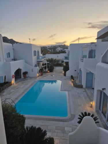 a villa with a swimming pool in front of a building at Mare Mare Mykonos in Ornos
