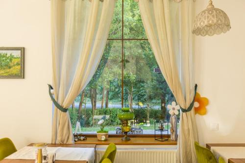 a dining room with a large window and a table at Pensiunea Sibiel in Sibiel