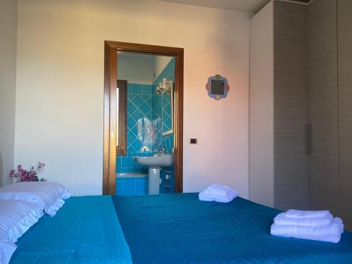 a bedroom with a bed and a bathroom with a sink at Rose House in Olbia
