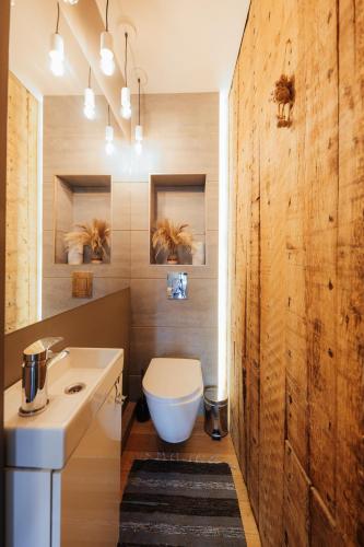 a bathroom with a white toilet and a sink at Melnais Dāvids in Liepāja