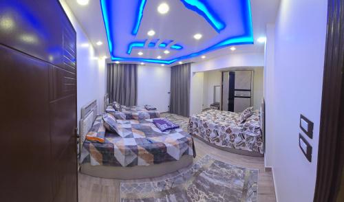 a room with two beds and a blue ceiling at Apartment with panoramic sea view sidi bshr Families only in Alexandria