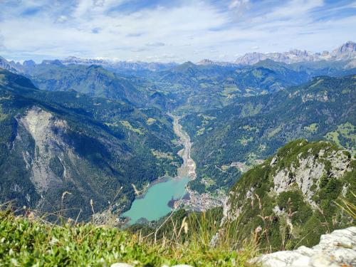 a view of a mountain valley with a lake at Sweet Dolomites Sauna & Jacuzzi in Agordo