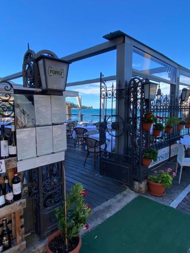 a deck with a gate and a table with wine bottles at Hotel Malcesine in Malcesine