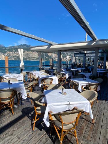 a restaurant with white tables and chairs on a boat at Hotel Malcesine in Malcesine