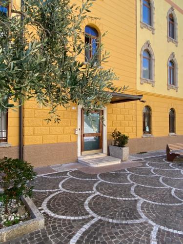 a yellow building with a stone pathway in front of a building at Hotel Malcesine in Malcesine