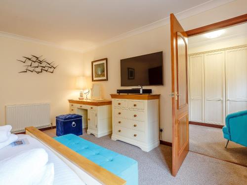 a bedroom with a bed and a tv and a dresser at Ard Taigh in Stron-fearnan