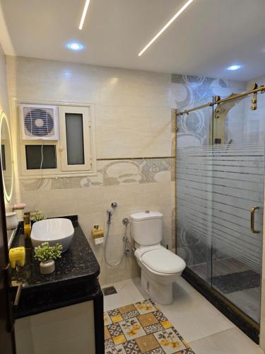 a bathroom with a toilet and a glass shower at Apartment with panoramic sea view sidi bshr Families only in Alexandria