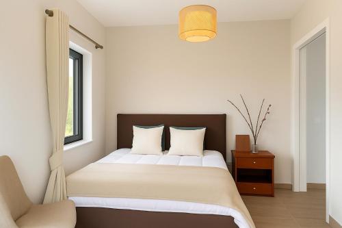 a bedroom with a large bed and a chair at Andriana's 3-Bedroom Countryside Retreat in Pandokrátor