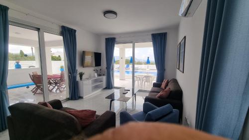 a living room with couches and a view of a pool at Almyra in Polis Chrysochous