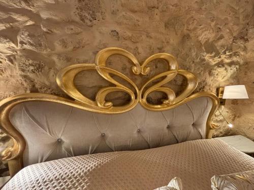 ein Bett mit goldenem Kopfteil in einem Zimmer in der Unterkunft Angelica's House in Noto