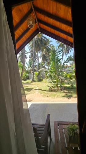 a view of a porch from a room with a window at The Dream Inn Guesthouse Passikudah in Batticaloa