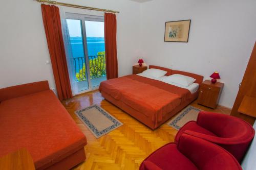 - une chambre avec un lit, un canapé et une fenêtre dans l'établissement Apartments Ankora, à Tučepi