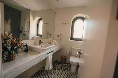 a white bathroom with a sink and a toilet at El Niu de Martinet in Martinet