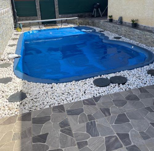 a blue swimming pool with rocks around it at Villa De la mer au volcan in Saint-Pierre