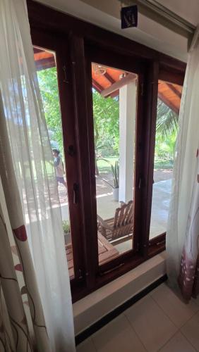 a window with a view of a porch at The Dream Inn Guesthouse Passikudah in Batticaloa