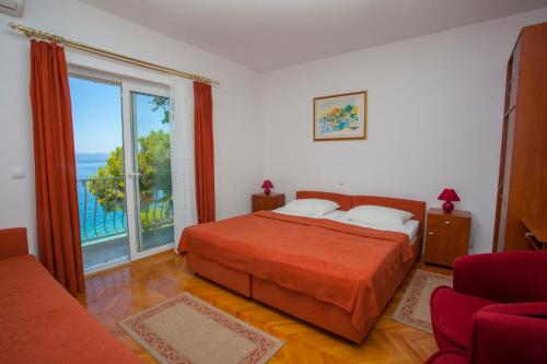 a bedroom with a bed and a large window at Villa Ankora Apartments Tučepi in Tučepi