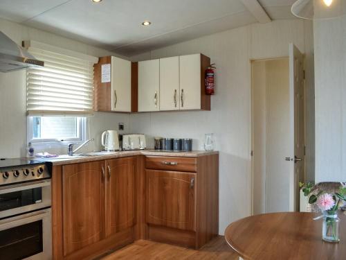 a kitchen with wooden cabinets and a wooden table at Kadelin Cove in Mainsriddle