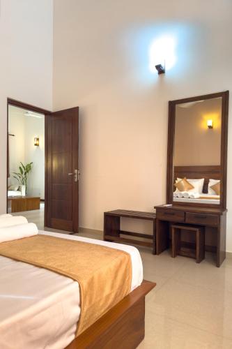 a bedroom with a bed and a large mirror at The Teak Ambalangoda in Ambalangoda