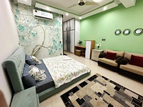 a bedroom with a bed and a couch in a room at AAA Guest House in Rawalpindi