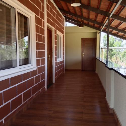 an empty hallway of a brick building with windows at Hasiru Bhoomi Resort 